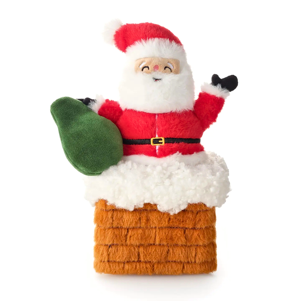Coco & Pud - Here Comes Santa. A plush Santa Claus in a red suit, white fur trim, black gloves, a green sack, in a plush brick chimney dog toy - The Foggy Dog