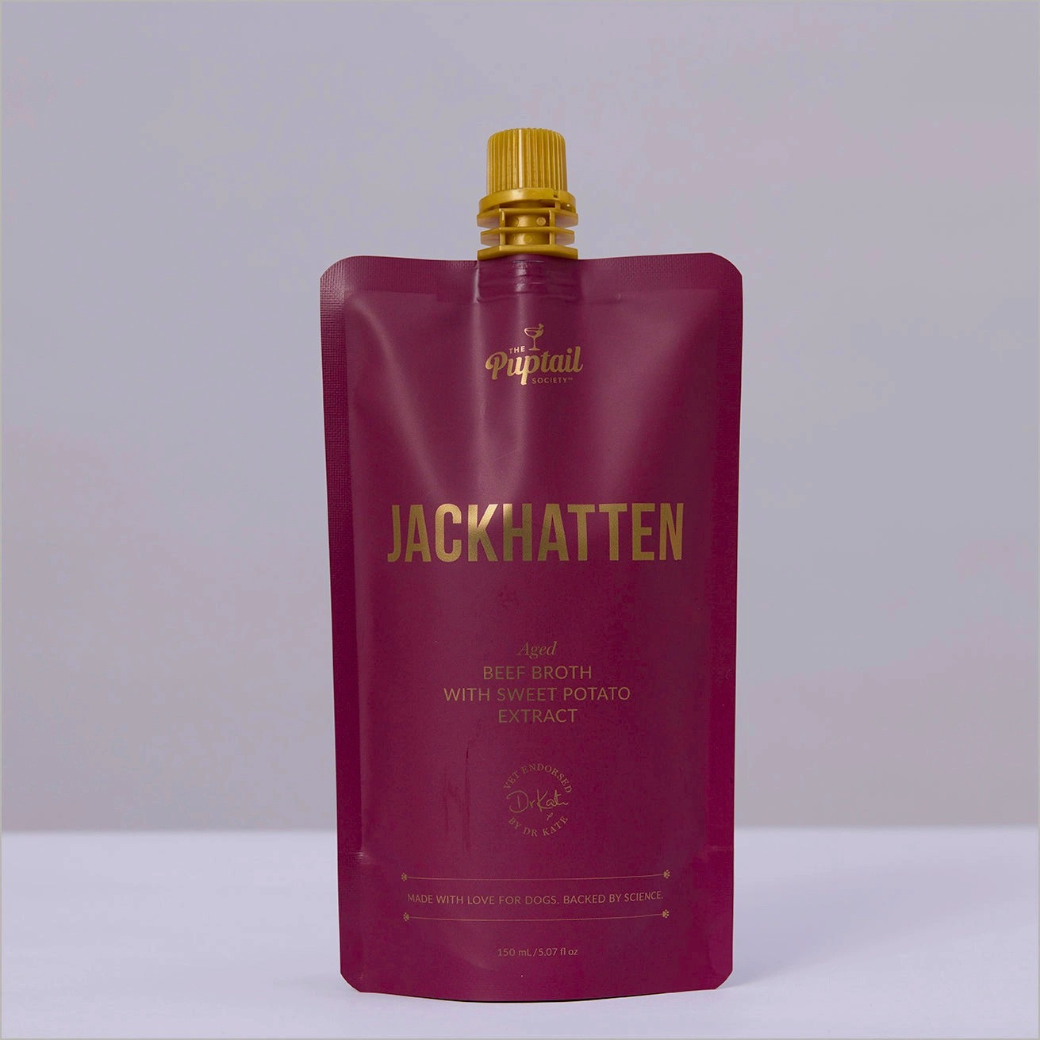 Coco & Pud - Jackhatten A 150 ml stand-up pouch of Puptail Society Jackhatten beef broth with sweet potato extract dog food, featuring a deep burgundy colour and gold lettering, with a gold cap.