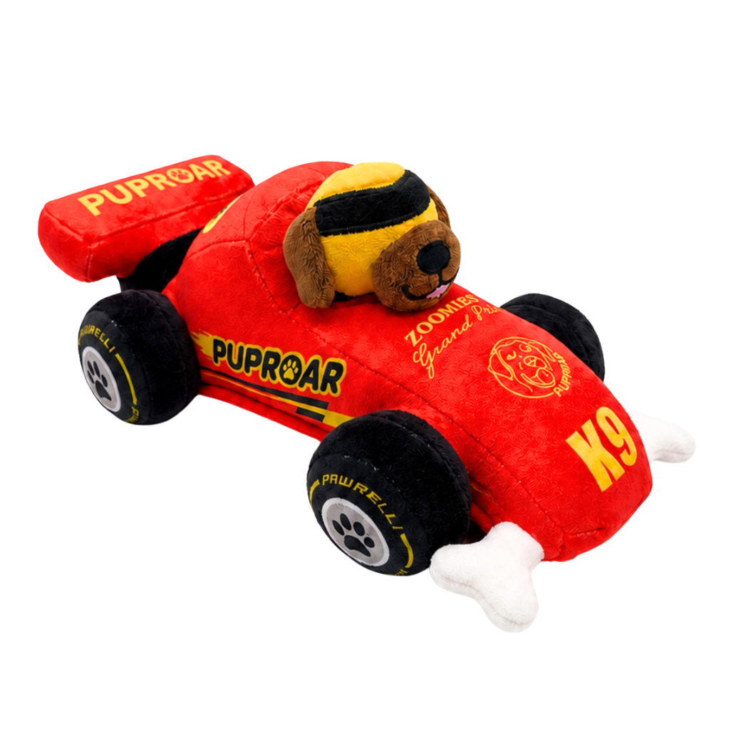 Coco & Pud - Puppy Prix Speeder Racecar plush Dog toy. A red plush dog race car toy with black wheels, yellow and black striped goggles on the dog head, and white bone-shaped front feet- Puproar