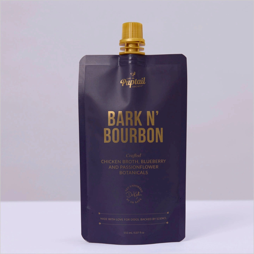 Coco & Pud - A 150ml stand-up pouch of Puptail Bark N' Bourbon chicken broth, blueberry and passionflower featuring a dark navy blue pouch with gold lettering and a gold cap - Puptail Society
