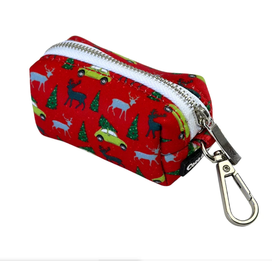 Coco & Pud - Deck The Paws, red Waste Bag Holder with a festive Christmas pattern of green cars, pine trees, and white deer, featuring a black brand label that reads 'Coco & Pud