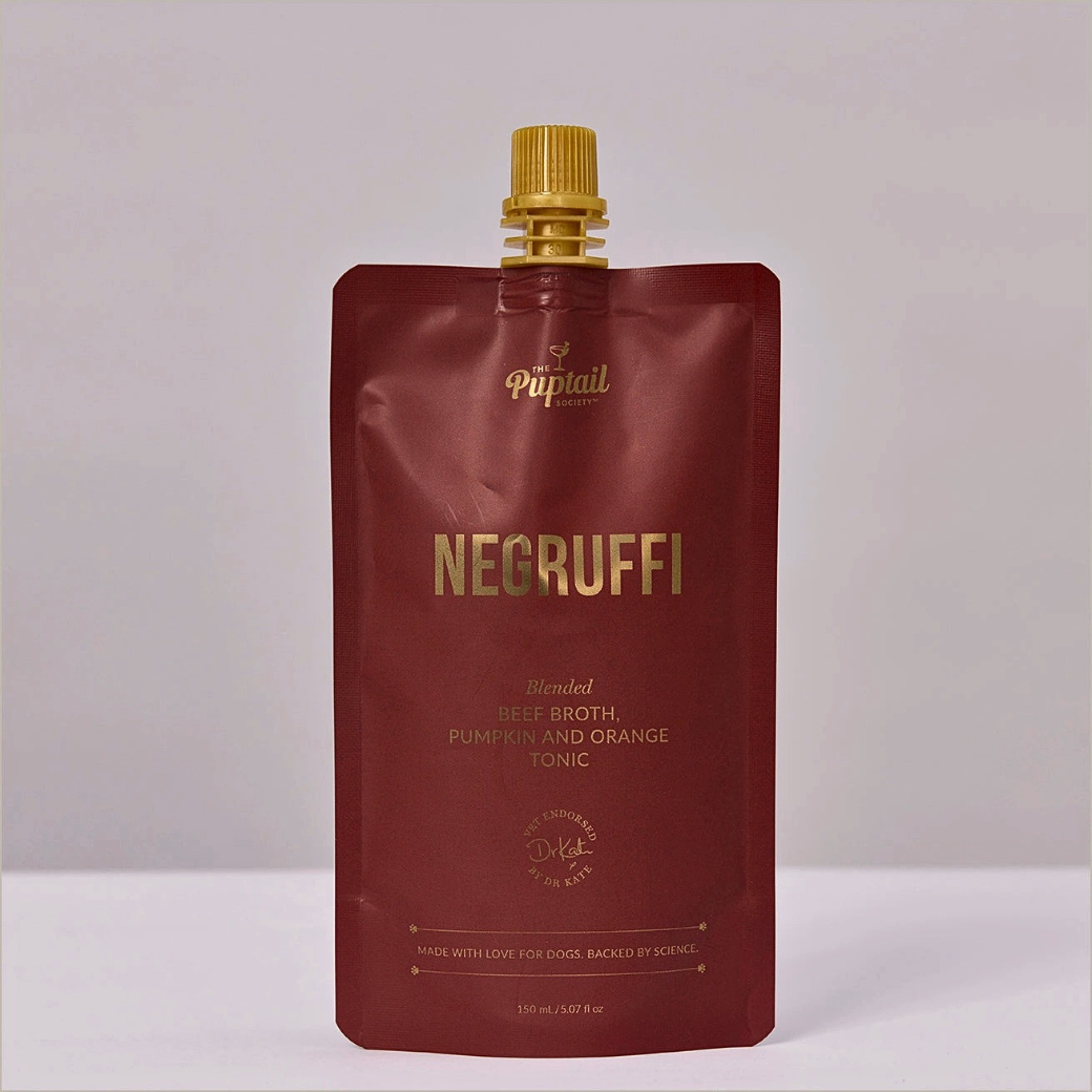 Coco & Pud - Negruffi blended Beef broth, pumpkin and orange tonic. A pouch of Pupmail Negruffi dog supplement, featuring a deep burgundy-red stand-up pouch with a gold spout cap and gold lettering - Puptail Society