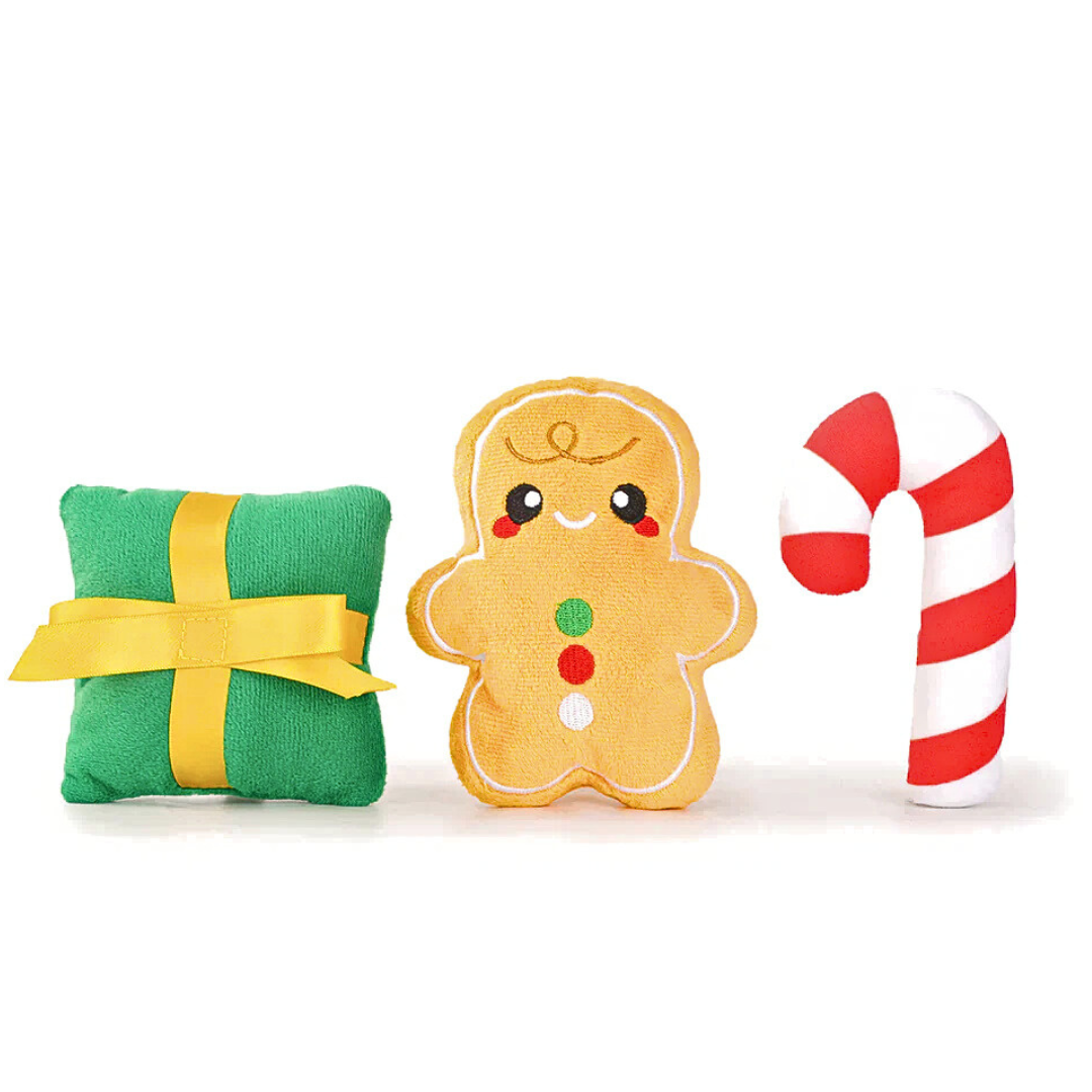 Coco & Pud three Christmas-themed plush toys on a white background: a green present, a yellow gingerbread man, and a red and white candy cane for inside the interactive Christmas Gift Bag dog toy - Hugsmart