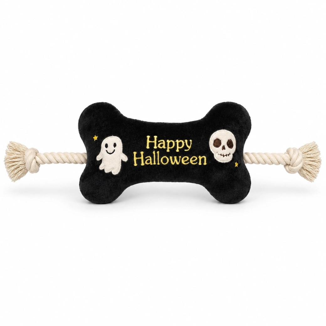 Coco & Pud - Happy Halloween Bone & Rope Dog Toy- A black bone-shaped dog toy with cream-colored rope ends and embroidered 'Happy Halloween' text, featuring a white ghost and skull design on a white background - Pet London