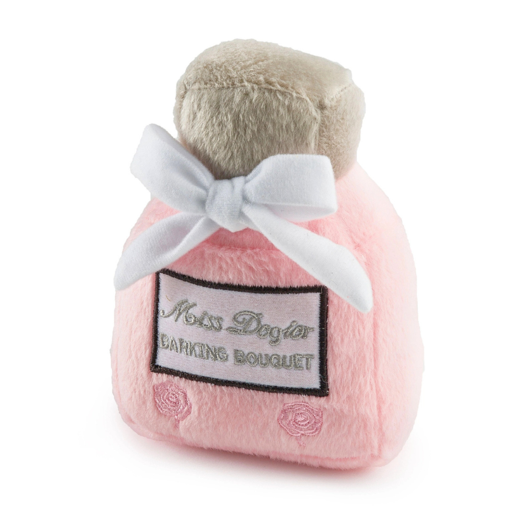 Coco & Pud  plush dog toy shaped like a perfume bottle, light pink with a white bow, and a label that reads 'Miss Dogior BARKING BOUQUET' - Haute Diggity Dog
